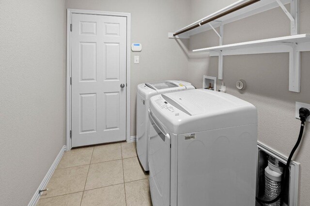 433 Vista Portola Loop, Liberty Hill, TX 78642 - laundry area with separate washer and dryer, light tile patterned floors, and baseboards
