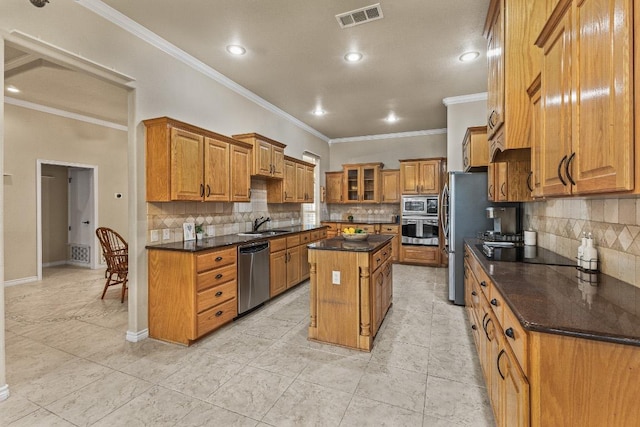 1420 Gomer Ln, Harker Heights, TX 76548 - kitchen featuring appliances with stainless steel finishes, brown cabinetry, crown molding, a kitchen island, and tasteful backsplash