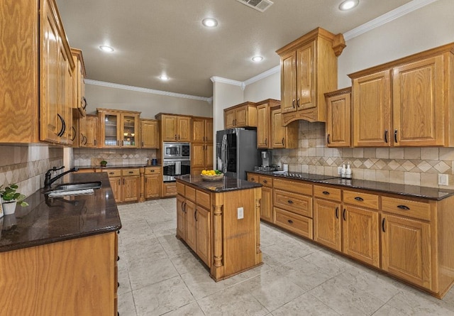 1420 Gomer Ln, Harker Heights, TX 76548 - kitchen featuring stainless steel appliances, brown cabinets, ornamental molding, backsplash, and a kitchen island