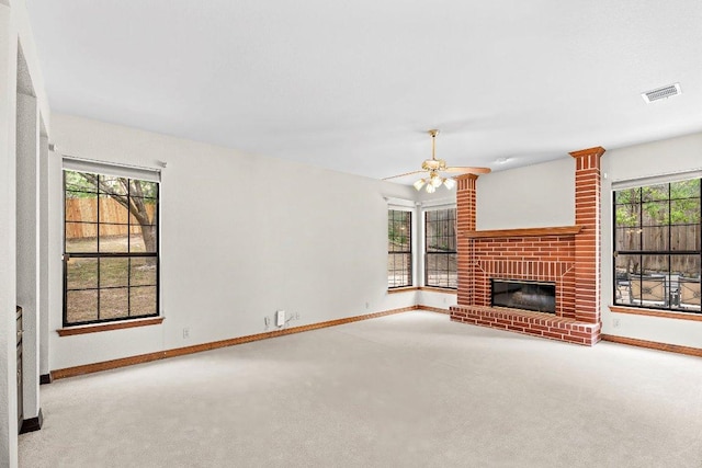 9002 Scotsman Dr, Austin, TX 78750 - unfurnished living room featuring carpet floors, baseboards, ceiling fan, a brick fireplace, and plenty of natural light