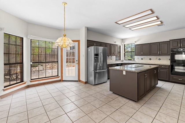 9002 Scotsman Dr, Austin, TX 78750 - kitchen featuring black appliances, a chandelier, a kitchen island, decorative backsplash, and light tile patterned floors