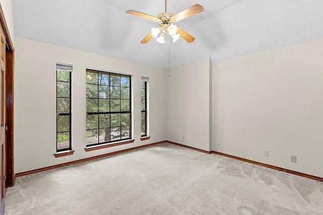 9002 Scotsman Dr, Austin, TX 78750 - empty room with light colored carpet, a ceiling fan, baseboards, and vaulted ceiling