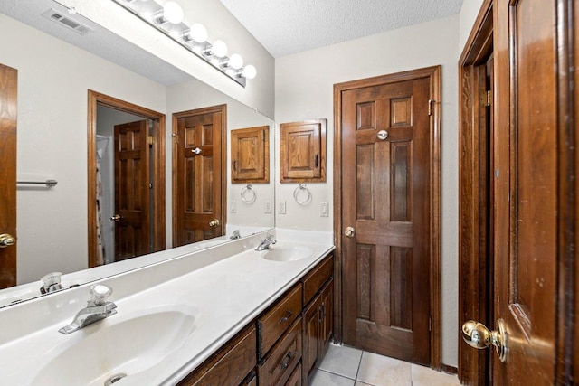 9002 Scotsman Dr, Austin, TX 78750 - full bathroom featuring double vanity, tile patterned floors, and a textured ceiling