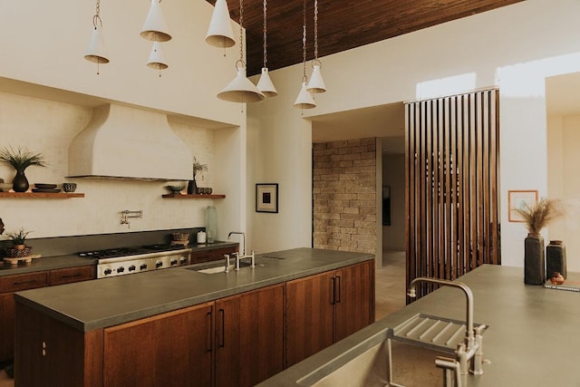 kitchen featuring custom range hood, a sink, dark countertops, wood ceiling, and range