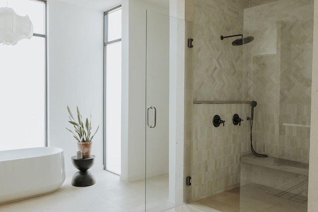 bathroom with a shower stall and tile patterned floors