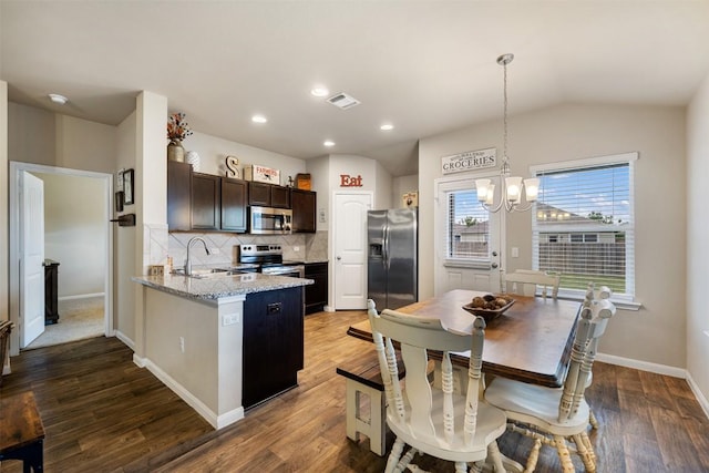 109 Dickinson Bayou Cv, Hutto, TX 78634 - kitchen featuring appliances with stainless steel finishes, a sink, a chandelier, tasteful backsplash, and wood finished floors