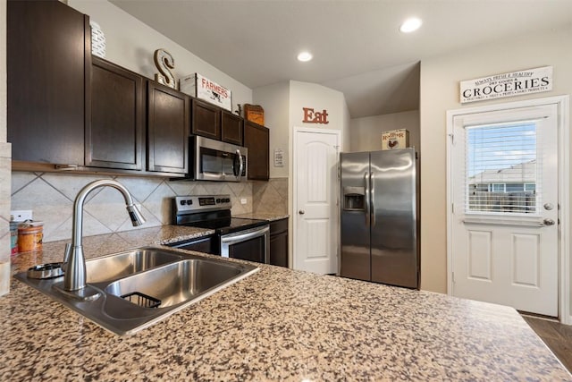 109 Dickinson Bayou Cv, Hutto, TX 78634 - kitchen with appliances with stainless steel finishes, a sink, dark brown cabinetry, decorative backsplash, and recessed lighting