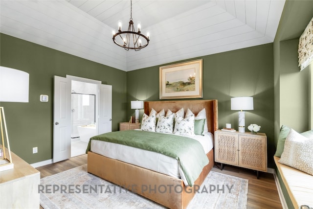 bedroom featuring a chandelier, wood finished floors, ensuite bath, baseboards, and wooden ceiling