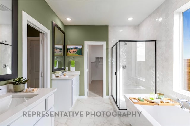full bath with a shower stall, marble finish floors, a freestanding tub, two vanities, and plenty of natural light