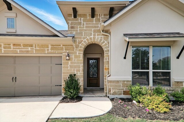2300 La Mirada St, Leander, TX 78641 - view of exterior entry featuring stucco siding, a garage, and stone siding