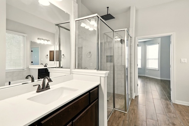 full bath with a stall shower, vanity, and wood finished floors