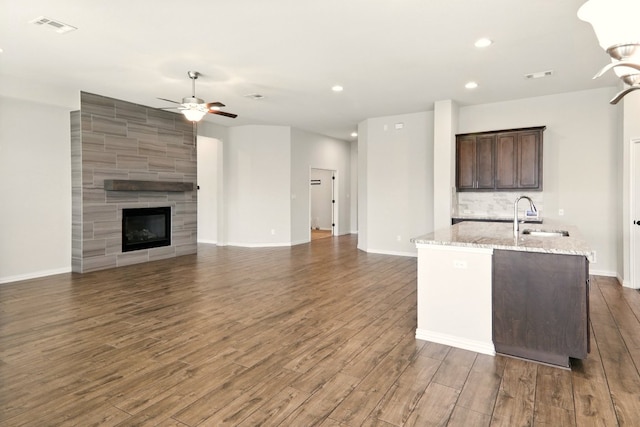 kitchen featuring ceiling fan, dark wood-style flooring, an island with sink, a sink, and recessed lighting