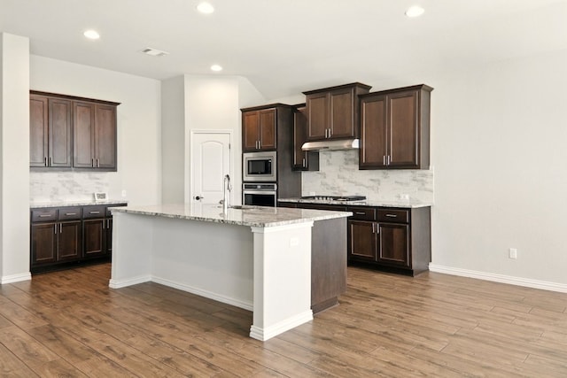 2300 La Mirada St, Leander, TX 78641 - kitchen featuring stainless steel appliances, under cabinet range hood, decorative backsplash, a sink, and recessed lighting