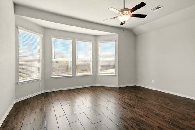 spare room featuring a ceiling fan, healthy amount of natural light, dark wood-type flooring, baseboards, and lofted ceiling