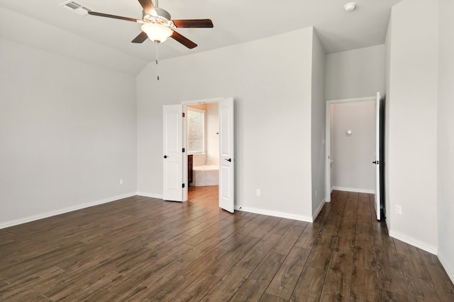 unfurnished bedroom with dark wood-style flooring, baseboards, vaulted ceiling, ensuite bathroom, and a ceiling fan