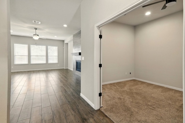 unfurnished living room with a ceiling fan, baseboards, a large fireplace, recessed lighting, and dark wood finished floors