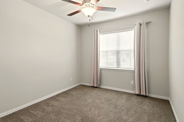 carpeted empty room with ceiling fan and baseboards