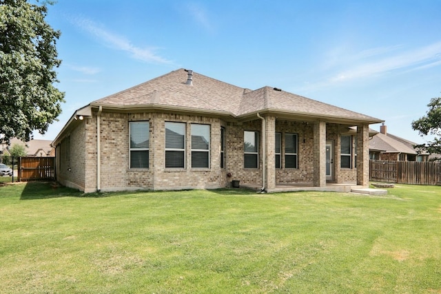 rear view of property featuring brick siding, a patio area, and roof with shingles