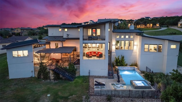 108 Stephanie Ln, Austin, TX 78738 - back of house at dusk featuring a balcony, a standing seam roof, stairs, stucco siding, and metal roof