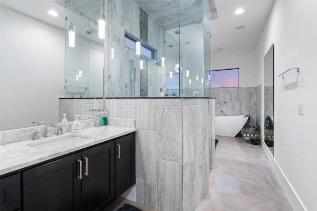 full bathroom with a shower stall, tile walls, vanity, finished concrete floors, and a freestanding bath
