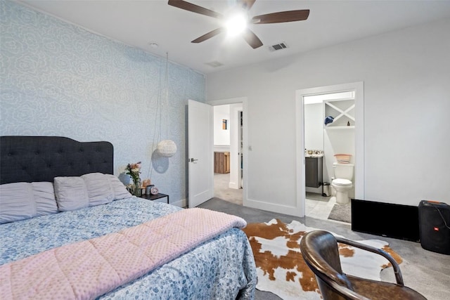 bedroom with carpet, wallpapered walls, ceiling fan, baseboards, and ensuite bathroom