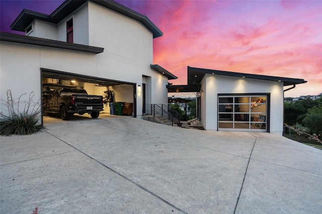 view of property exterior featuring driveway, stucco siding, and an attached garage
