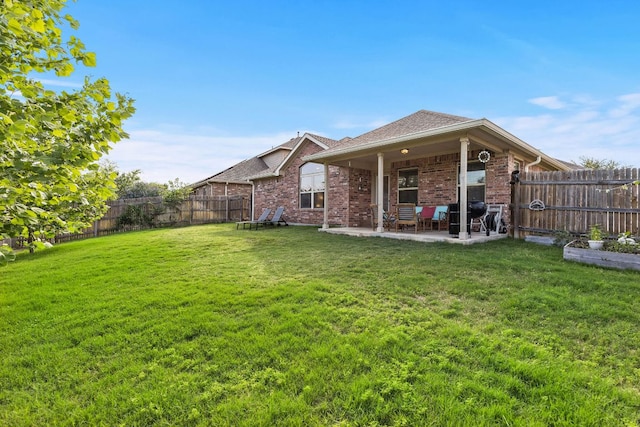 back of property with brick siding, a patio area, and roof with shingles