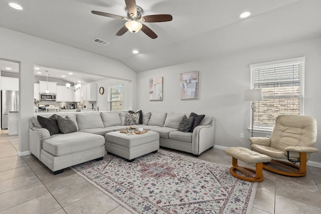 living room with a ceiling fan, lofted ceiling, recessed lighting, baseboards, and light tile patterned floors