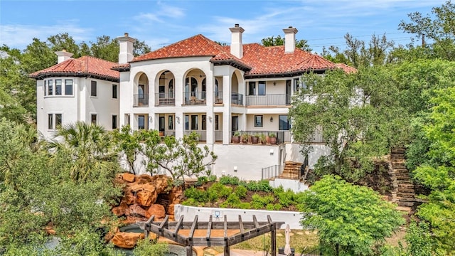 1710 Mount Larson Rd, Austin, TX 78746 - rear view of house featuring a balcony, stucco siding, and a tile roof