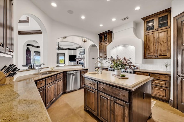 1710 Mount Larson Rd, Austin, TX 78746 - kitchen with stainless steel dishwasher, a sink, a center island with sink, arched walkways, and recessed lighting