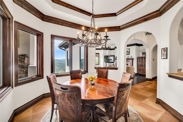 1710 Mount Larson Rd, Austin, TX 78746 - tiled dining area featuring arched walkways, a chandelier, baseboards, crown molding, and a raised ceiling