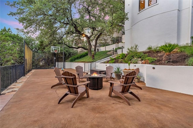 1710 Mount Larson Rd, Austin, TX 78746 - patio terrace at dusk featuring an outdoor fire pit and a patio area