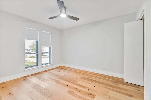 empty room with wood finished floors, baseboards, and a ceiling fan