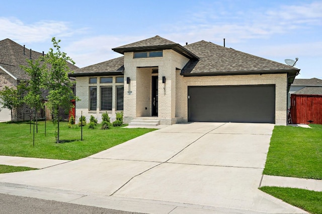 14505 Kira Ln, Manor, TX 78653 - view of front of house with brick siding, a garage, concrete driveway, and roof with shingles