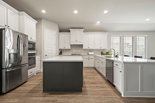 14505 Kira Ln, Manor, TX 78653 - kitchen featuring appliances with stainless steel finishes, a sink, a kitchen island, decorative backsplash, and recessed lighting