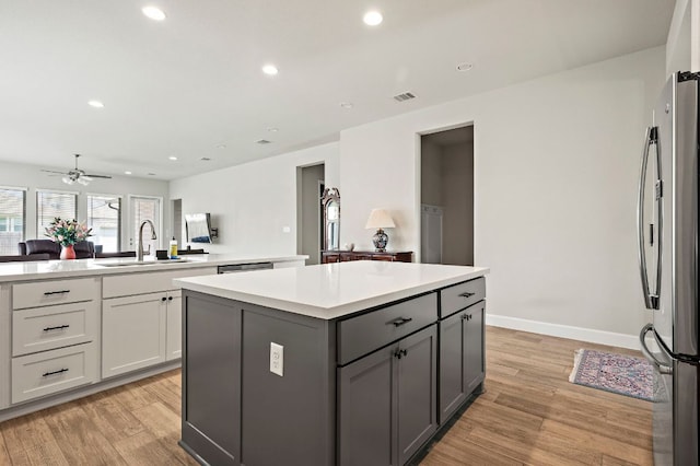14505 Kira Ln, Manor, TX 78653 - kitchen featuring appliances with stainless steel finishes, a sink, a kitchen island, light wood-style floors, and recessed lighting