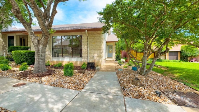 8807 Honeysuckle Trl, Austin, TX 78759 - view of front of house featuring stone siding, a shingled roof, cooling unit, and a front lawn