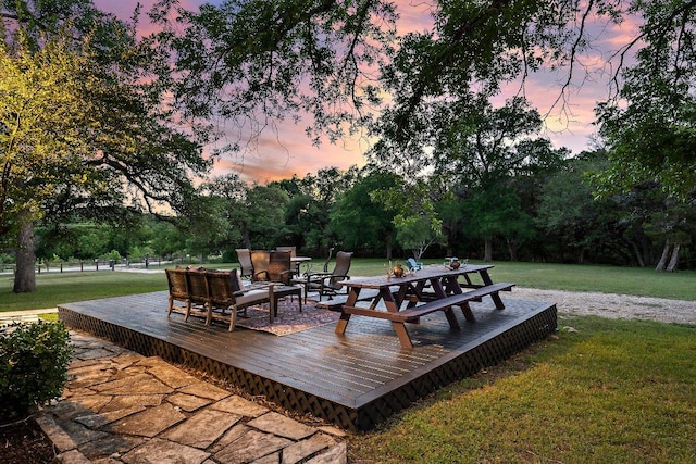 wooden deck featuring a lawn, outdoor lounge area, view of scattered trees, and outdoor dining area