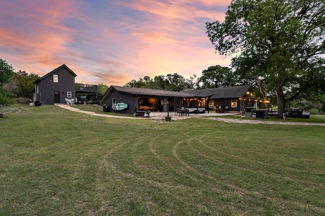 back of property featuring a patio area, a yard, and outdoor lounge area