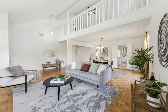 living area with a towering ceiling and a chandelier