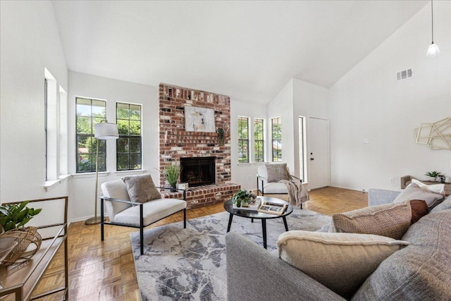 living room featuring plenty of natural light, high vaulted ceiling, a brick fireplace, and baseboards