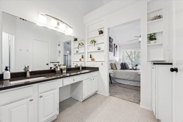bathroom featuring connected bathroom, ceiling fan, double vanity, and built in shelves