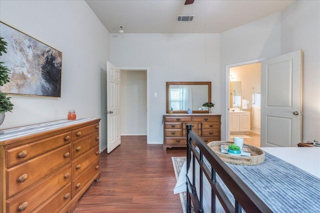 bedroom with dark wood-style floors, baseboards, ensuite bathroom, and a ceiling fan