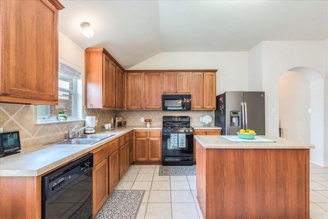 kitchen featuring black appliances, a sink, arched walkways, vaulted ceiling, and light tile patterned floors