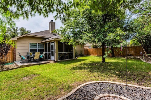 rear view of property featuring a sunroom, a chimney, and a patio area