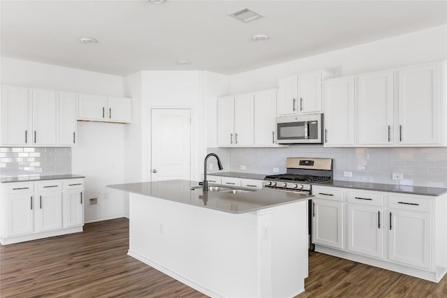 1203 Diggy Dr, Austin, TX 78748 - kitchen featuring stainless steel appliances, a sink, tasteful backsplash, dark wood-style flooring, and a kitchen island with sink