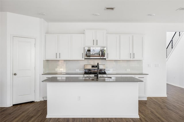 1203 Diggy Dr, Austin, TX 78748 - kitchen featuring appliances with stainless steel finishes, dark wood-style flooring, and tasteful backsplash