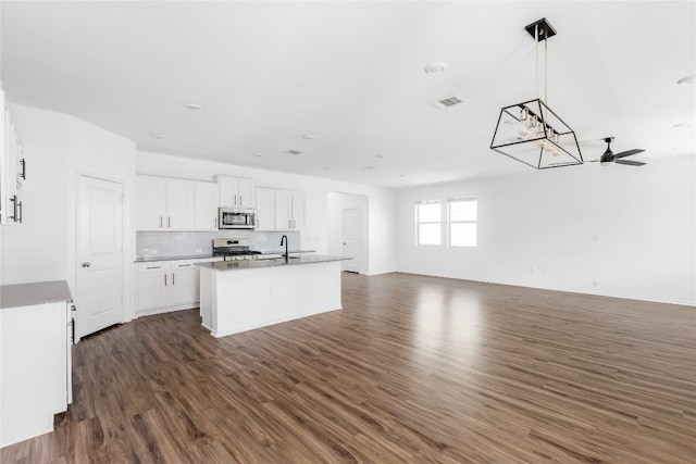 1203 Diggy Dr, Austin, TX 78748 - kitchen with stainless steel appliances, open floor plan, dark wood finished floors, and an island with sink