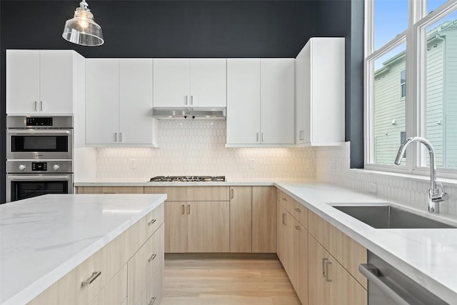 2805 Mccurdy St Unit 2, Austin, TX 78723 - kitchen featuring a sink, stainless steel appliances, light wood-style floors, backsplash, and light brown cabinetry
