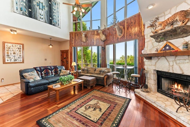 9038 Eagles Vw, Spring Branch, TX 78070 - living room with a towering ceiling, a stone fireplace, hardwood / wood-style floors, and a ceiling fan